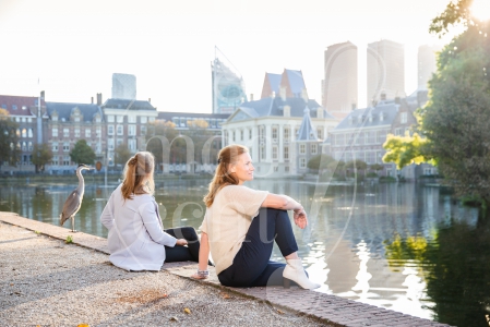 Vriendinnen zitten naast elkaar bij op Haagse Hofvijver bij zonsopkomst