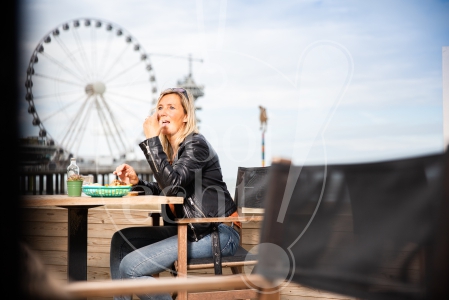 Vrouw eet een broodje op de boulevard