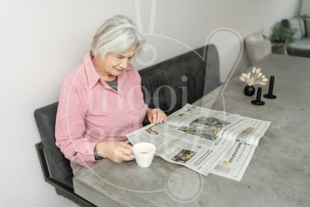 vrouw leest de krant en drinkt koffie 1