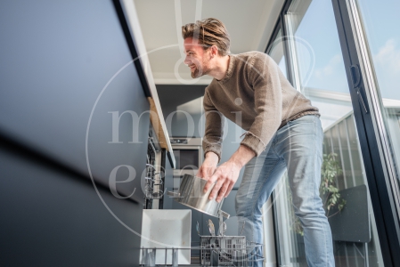 man ruimt de vaatwasser in 1