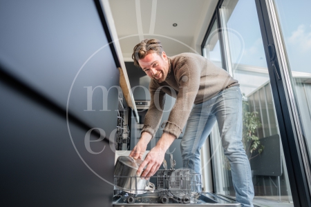 man ruimt de vaatwasser in 2