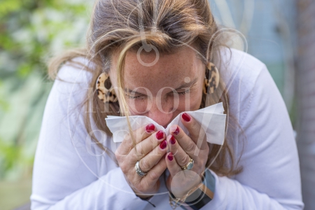 Vrouw niest tijdens Coronacrisis