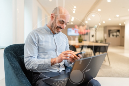 man aan het werk op zijn laptop en telefoon 1