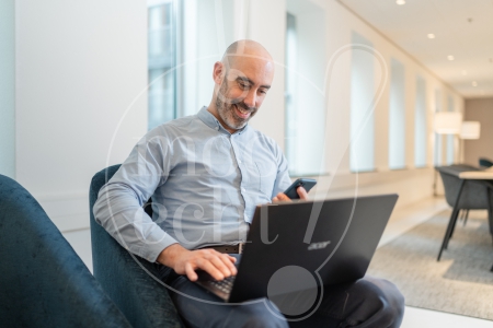 man aan het werk op zijn laptop en telefoon 3