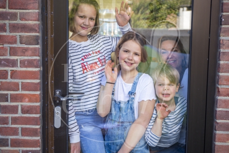 Gezin zwaait naar vrienden of familie tijdens Coronacrisis